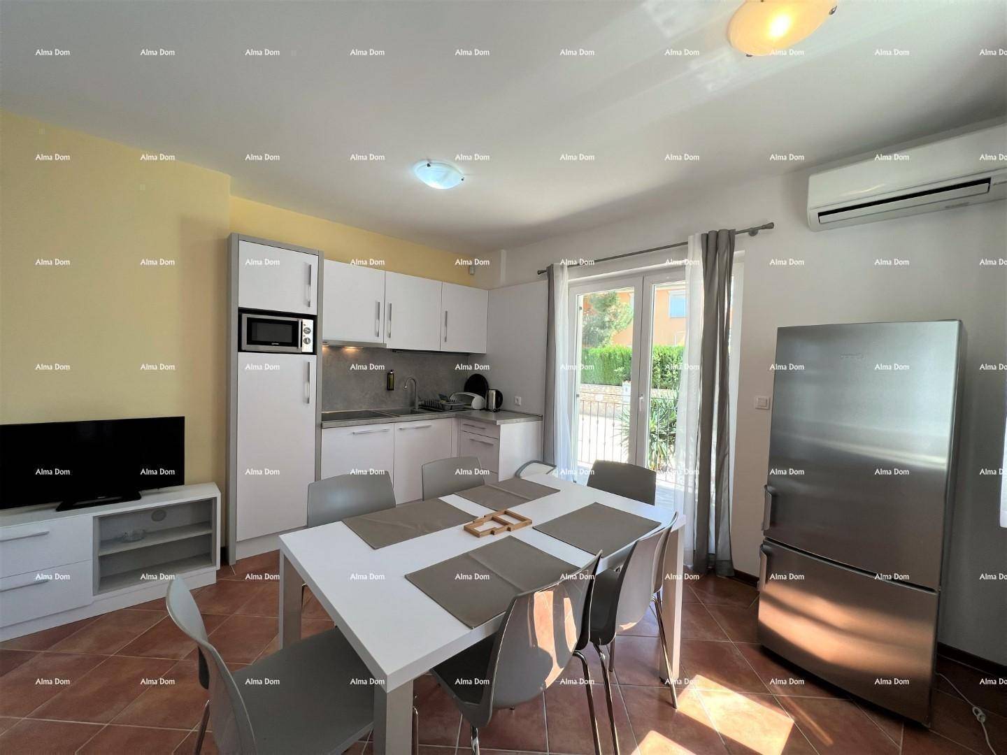 Moderne Küchenzeile mit Essbereich und Blick ins Grüne durch das Fenster.