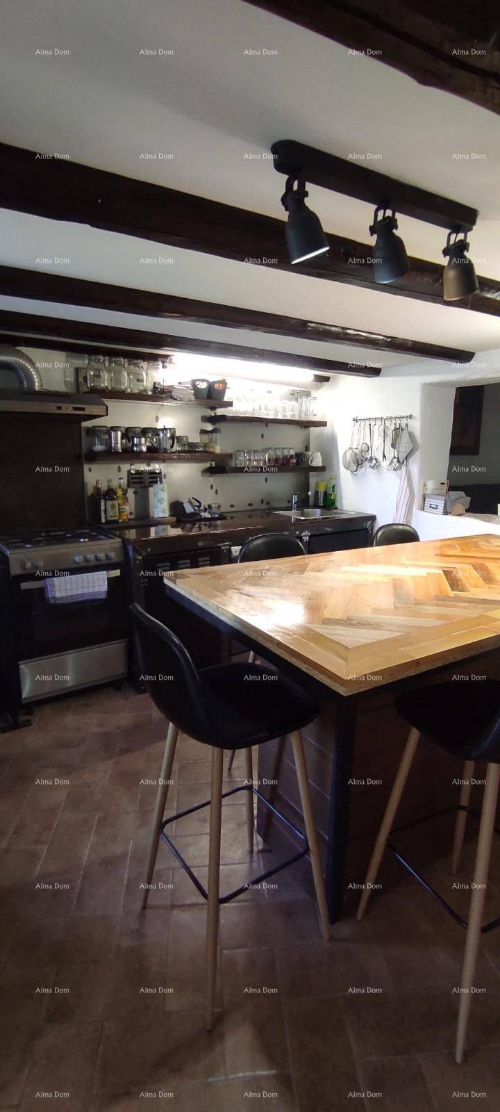 Detailansicht der Küche mit großem Holztisch, Barhockern und offener Regalgestaltung.