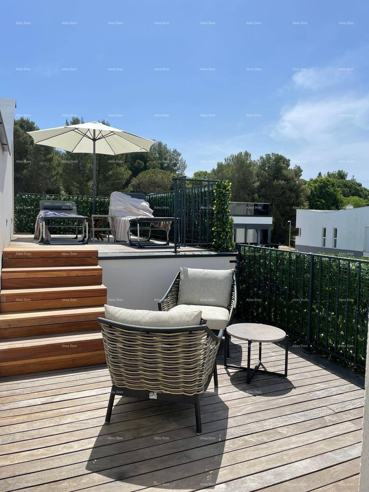 Geräumige Dachterrasse mit Holzdeck, bequemen Sitzmöbeln und weitem Blick ins Grüne.