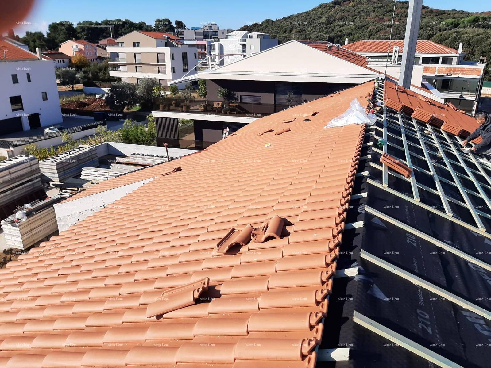 Dach im Bau mit verlegten Terrakotta-Ziegeln und vorbereiteter Unterkonstruktion.
