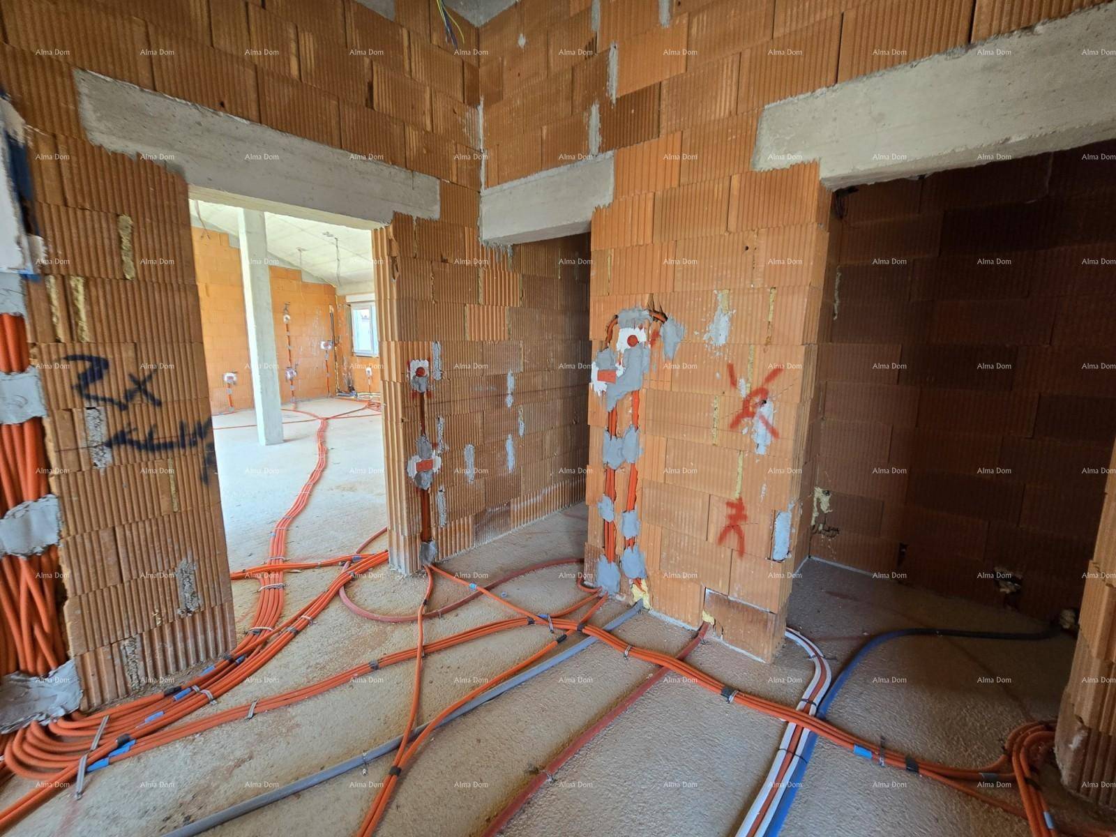 Flur im Rohbau mit Ziegelwänden, Betondecke und vorbereiteten Elektroinstallationen.