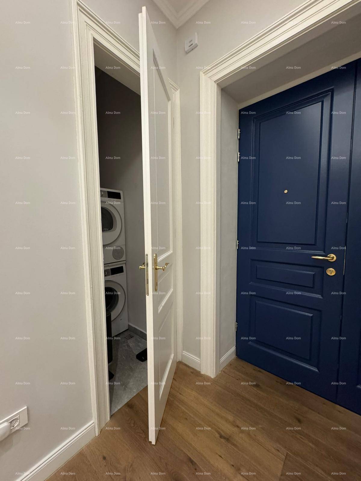 Kleiner Hauswirtschaftsraum mit Waschmaschine und Trockner hinter einer Tür.