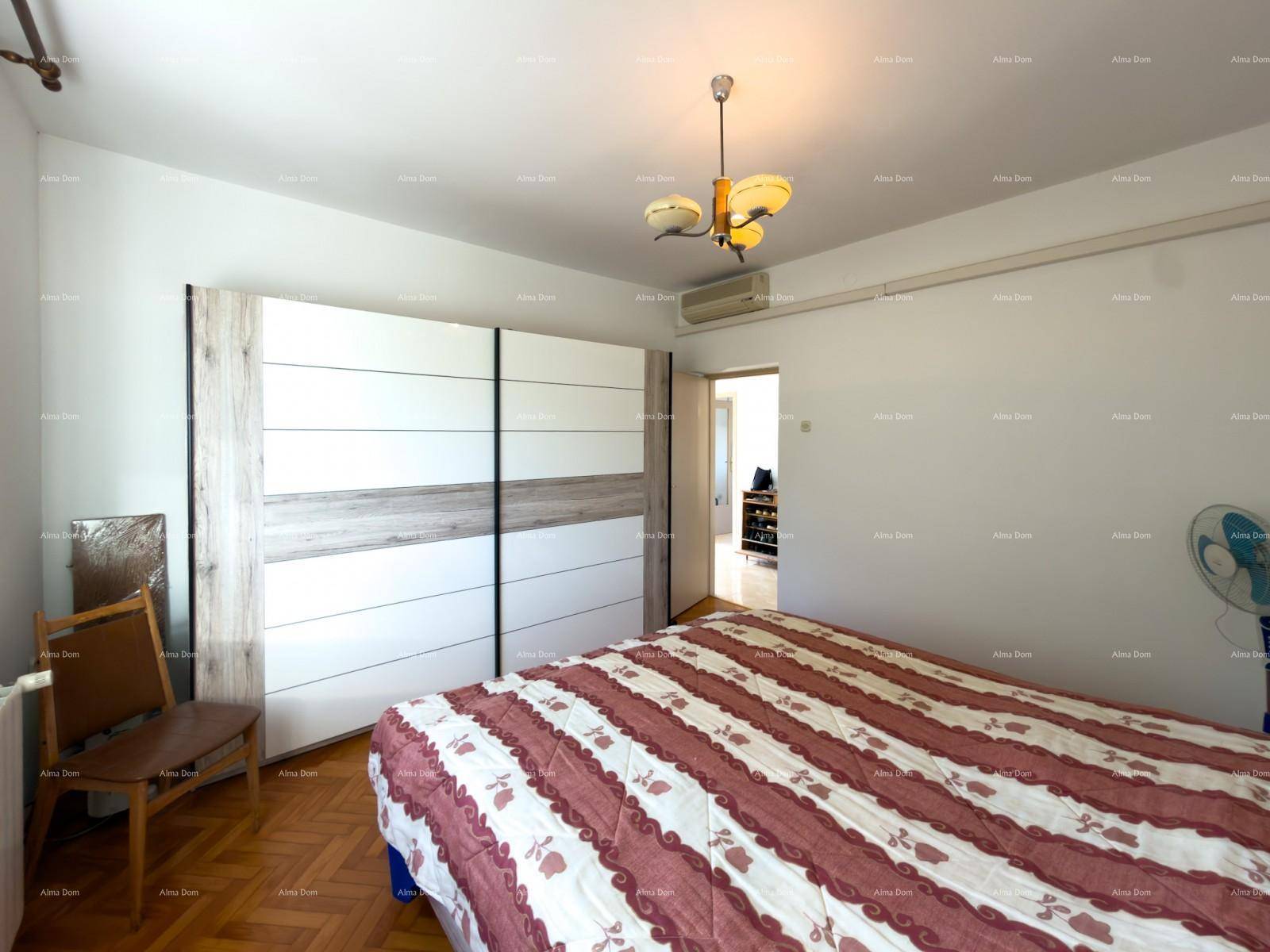 Schlafzimmer mit modernem Schiebetürenschrank und offenem Zugang zu einem weiteren Raum.