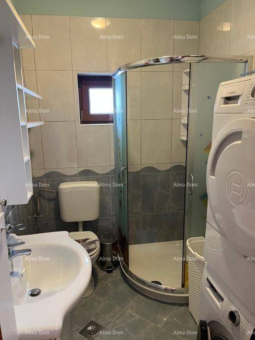 Badezimmer mit Duschkabine, WC, Waschbecken und Waschmaschine, komplett gefliest.