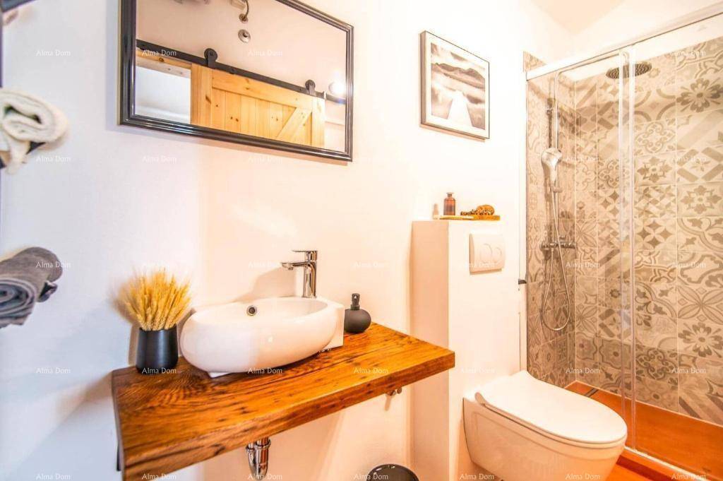 Stilvolles Badezimmer mit modernem Waschbecken auf Holzplatte, Spiegel und Duschkabine.
