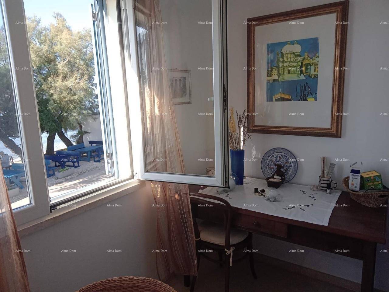 Kleiner Arbeitsbereich mit Holztisch und Fenster, das einen Blick ins Freie bietet.