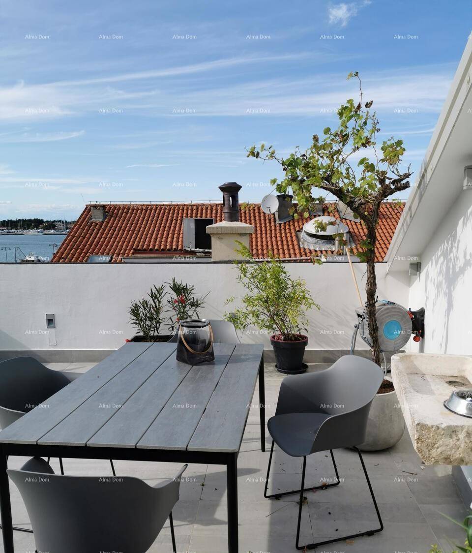 Dachterrasse mit Esstisch, Stühlen und Blick auf das Meer und die umliegenden Dächer.
