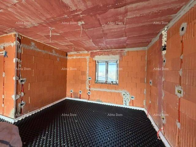 Unfertiges Schlafzimmer mit Ziegelwänden, Fußbodenheizungsvorbereitung und Fenster für natürliches Licht.