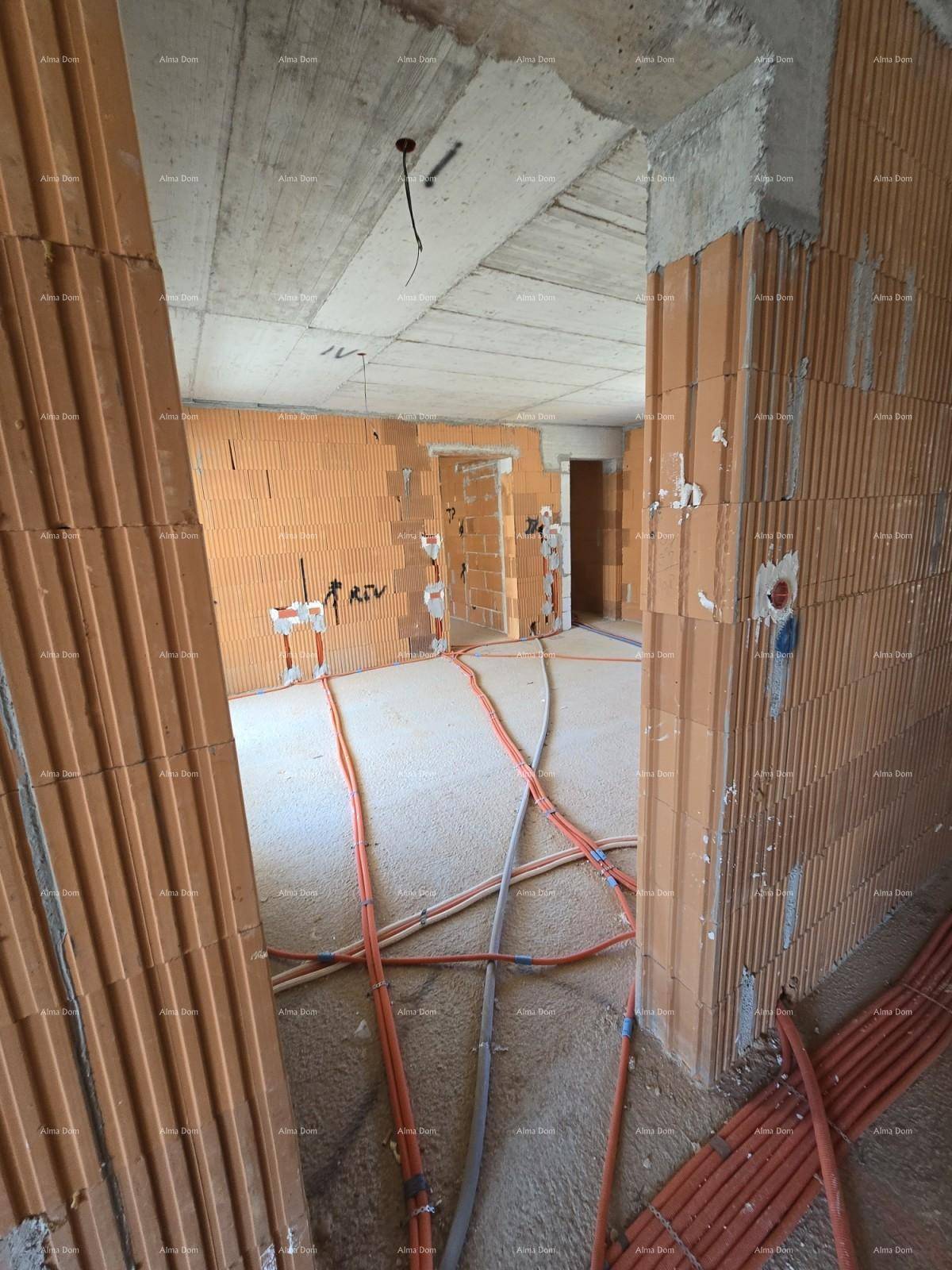 Rohbau eines Raumes mit unverputzten Ziegelwänden, Betonboden und sichtbaren Installationen.