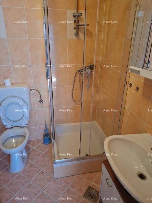 Badezimmer mit Duschkabine, Toilette und Waschbecken, komplett gefliest in warmen Farbtönen.