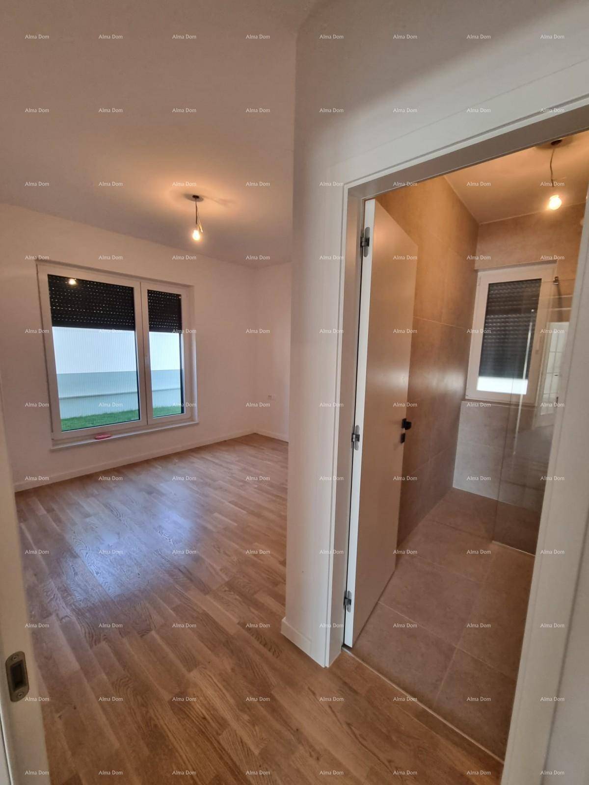 Schlafzimmer mit Parkettboden und Zugang zu einem modernen Badezimmer.