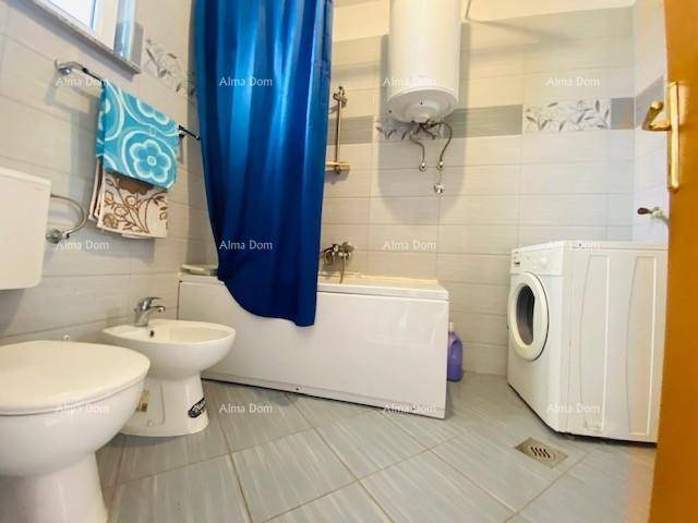 Badezimmer mit Badewanne, Bidet, Toilette und Waschmaschine, gefliest in hellen Tönen.