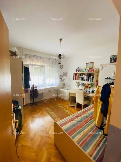 Helles Schlafzimmer mit Parkettboden, Einzelbett und Schreibtisch am Fenster.