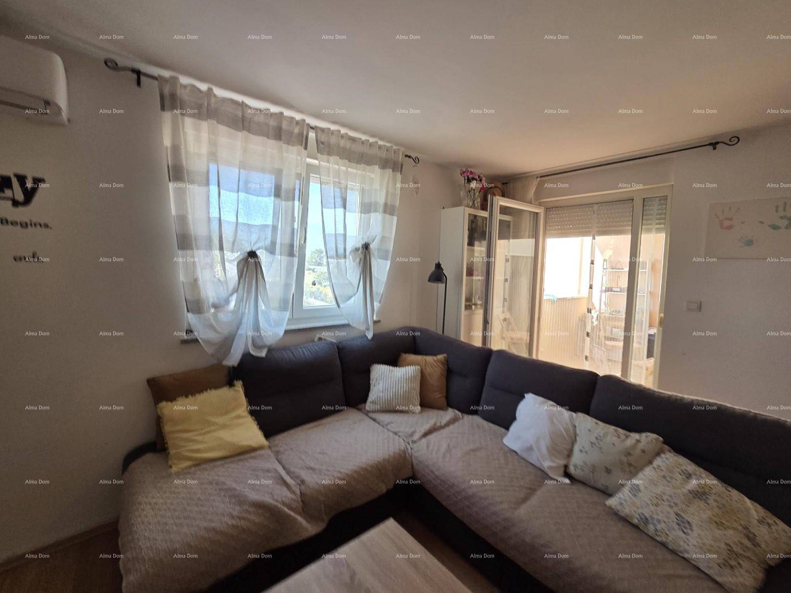 Gemütliches Wohnzimmer mit Ecksofa, Vorhängen und Zugang zu einem Balkon.