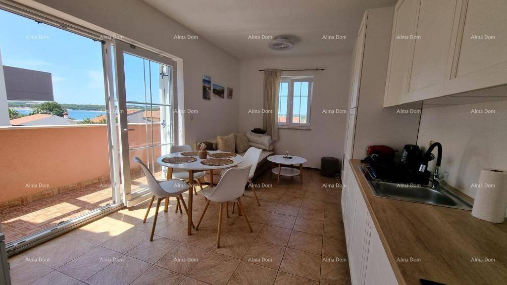 Kombinierter Wohn- und Essbereich mit moderner Küche und direktem Zugang zum Balkon.