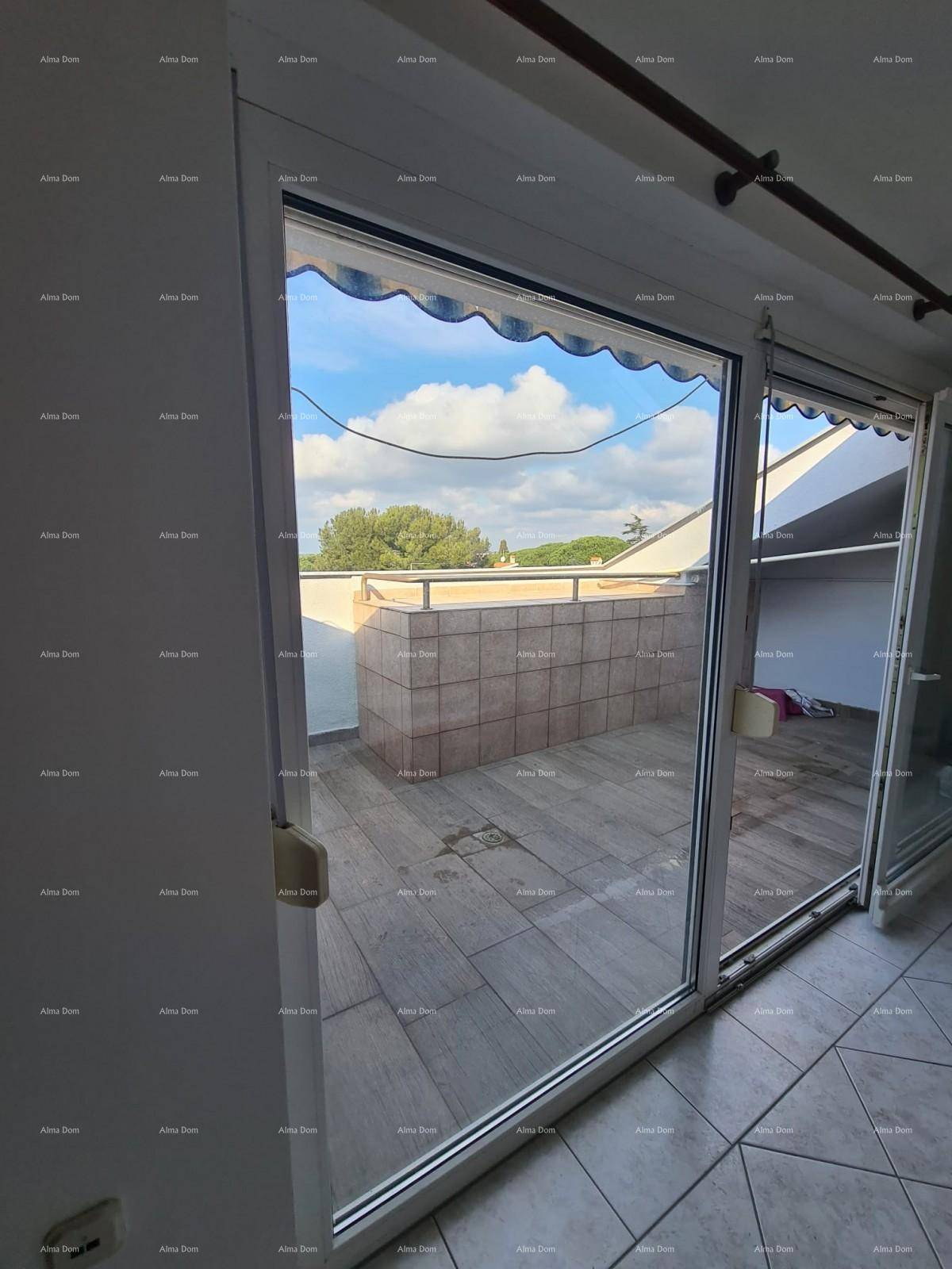 Innenansicht mit großen Schiebetüren, die zu einer gefliesten Terrasse mit Markise führen.
