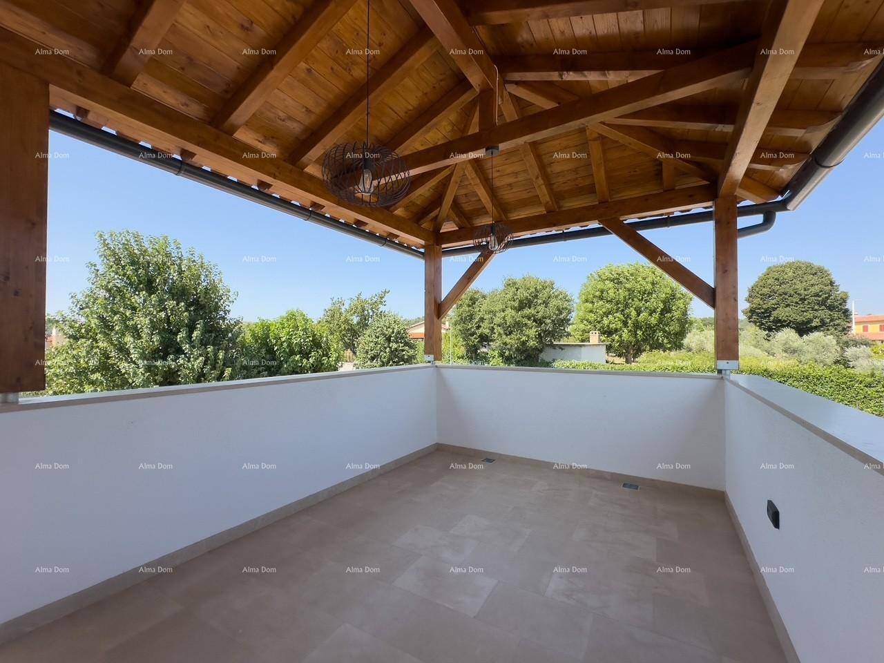 Große, überdachte Terrasse mit Holzbalken und freiem Blick auf die grüne Umgebung.