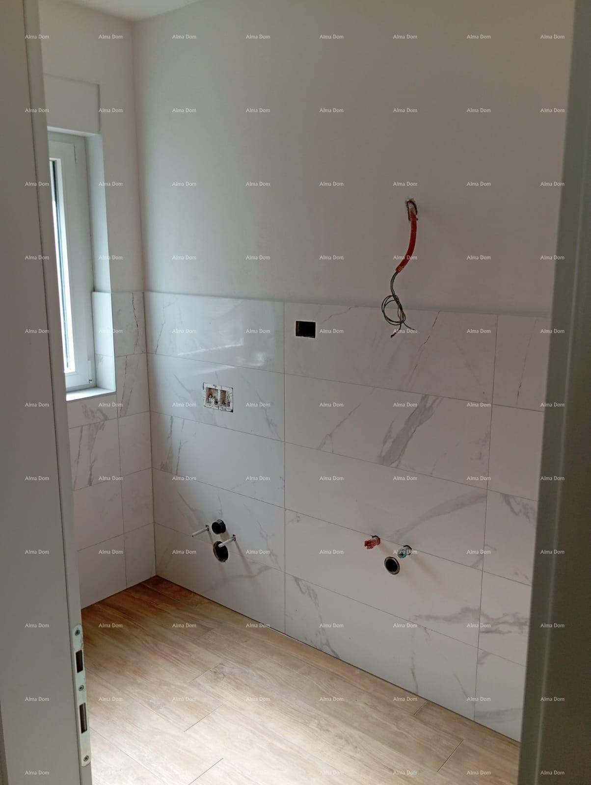 Unfertiges Badezimmer mit Marmoroptik-Fliesen an den Wänden und einem Fenster für Tageslicht.