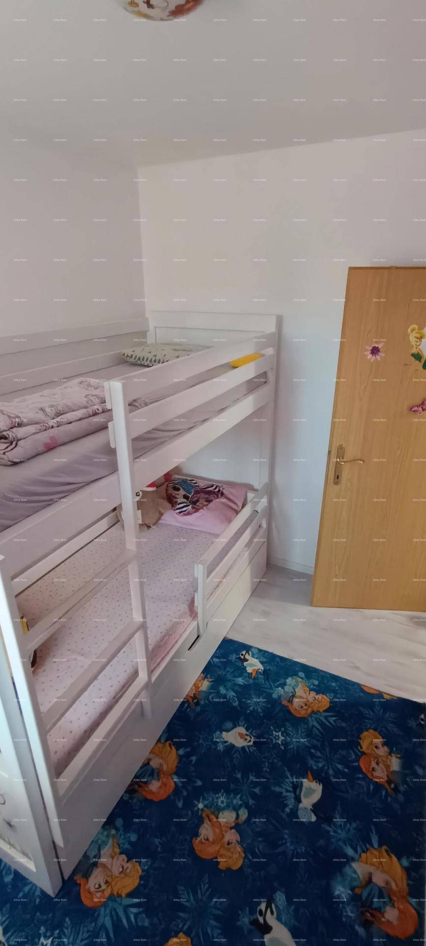 Kinderzimmer mit Etagenbett und einem bunten Teppich, ideal für Geschwister oder Gäste.
