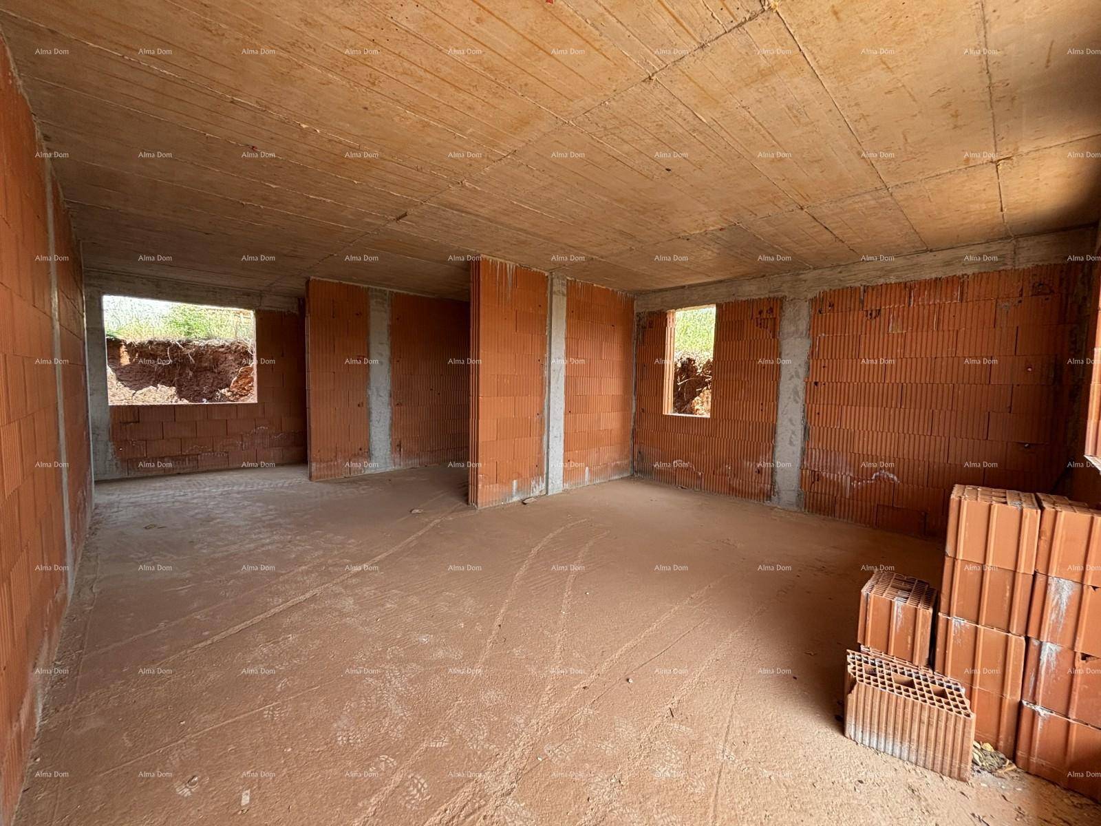 Unfertiger Innenraum eines Neubaus mit Ziegelwänden und Betonboden, bereit für weitere Bauarbeiten.