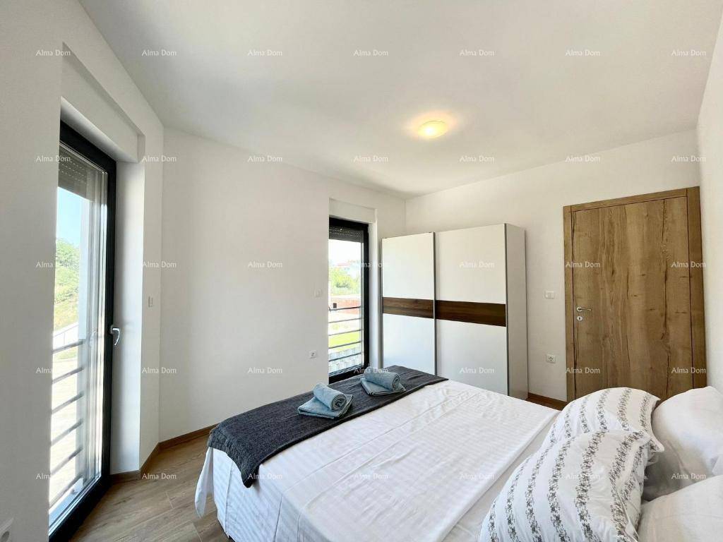 Helles Schlafzimmer mit Doppelbett, Schrank und Zugang zum Balkon.