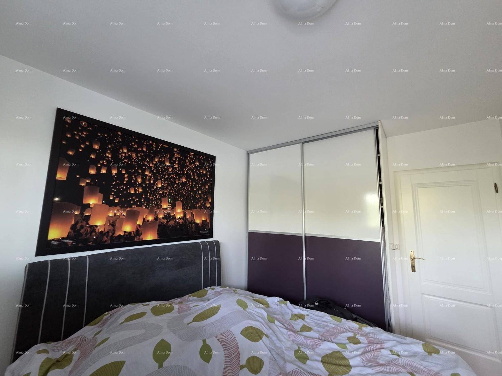 Schlafzimmer mit großem Wandbild über dem Bett und einem praktischen Einbauschrank.