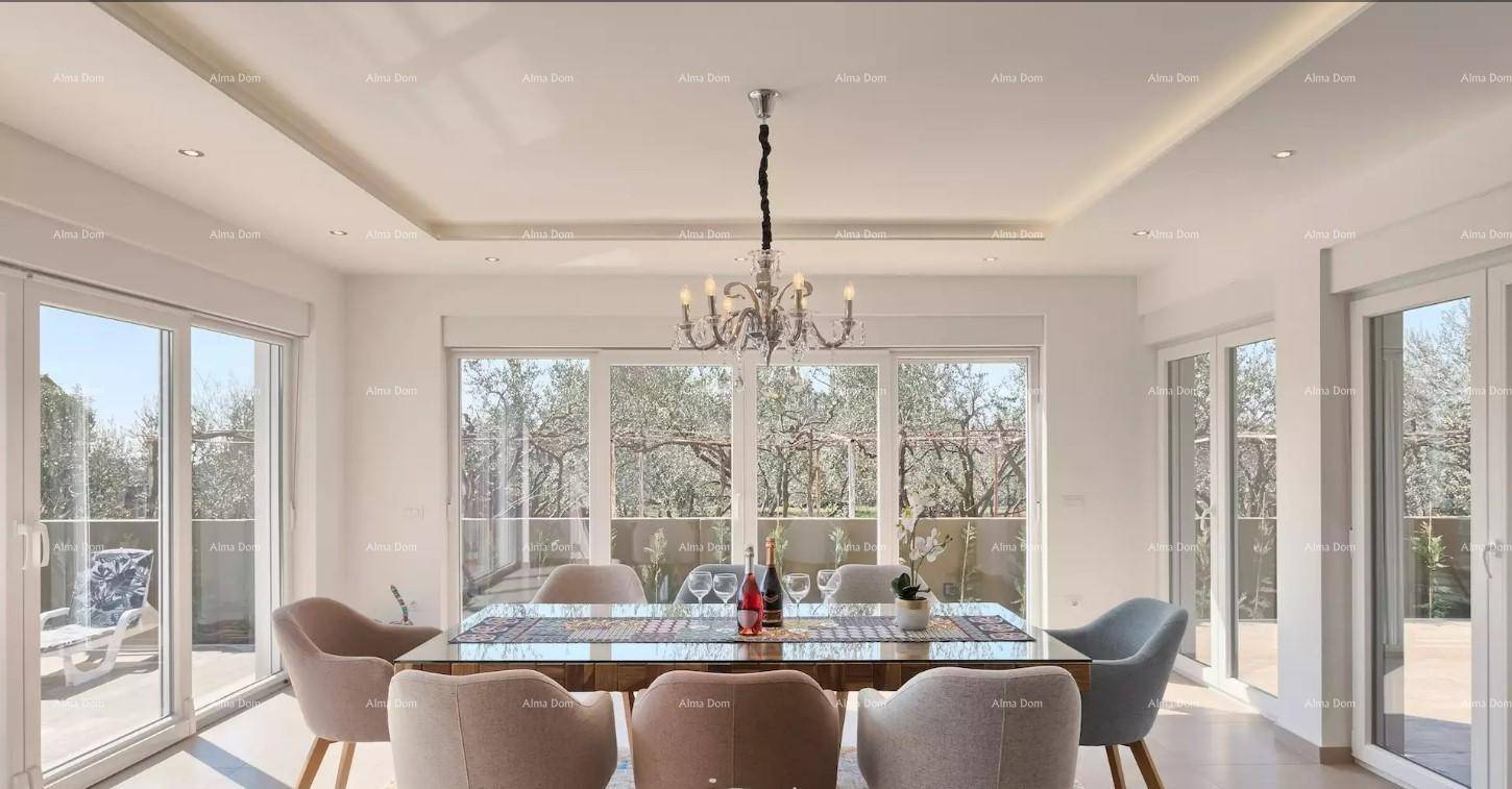 Eleganter Essbereich mit großem Holztisch, Kronleuchter und bodentiefen Fenstern mit Blick ins Grüne.