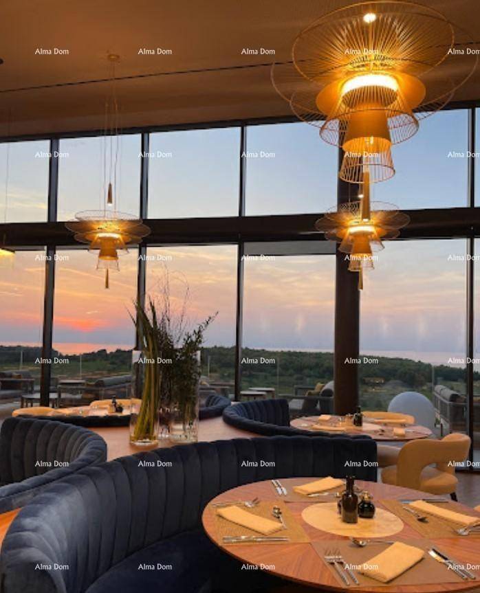 Elegantes Restaurant mit stilvollen Leuchten, bequemen Sitzgelegenheiten und Panoramablick bei Sonnenuntergang.