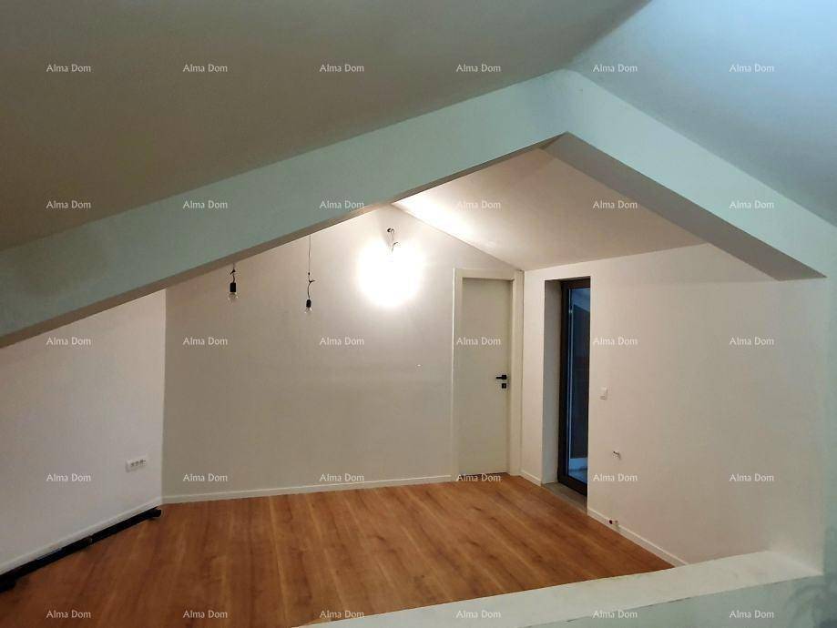 Heller Dachbodenraum mit schrägen Wänden und Holzfußboden, unmöbliert und geräumig.