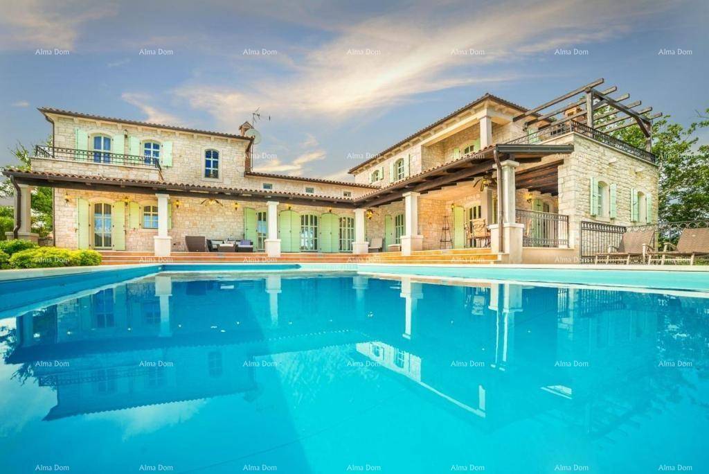 Einladender Pool mit türkisfarbenem Wasser vor der traditionellen Steinvilla unter einem leicht bewölkten Himmel.