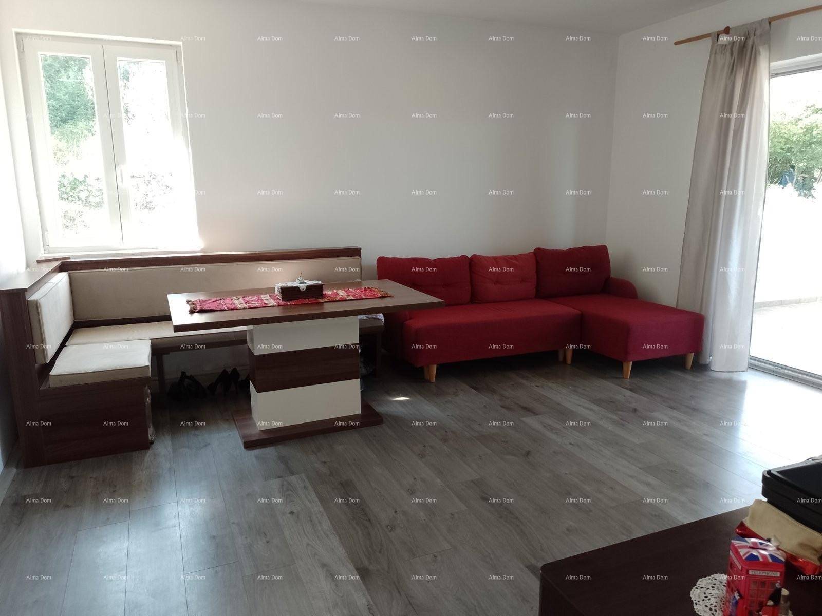 Heller Wohn- und Essbereich mit Eckbank, rotem Sofa und modernem Laminatboden.