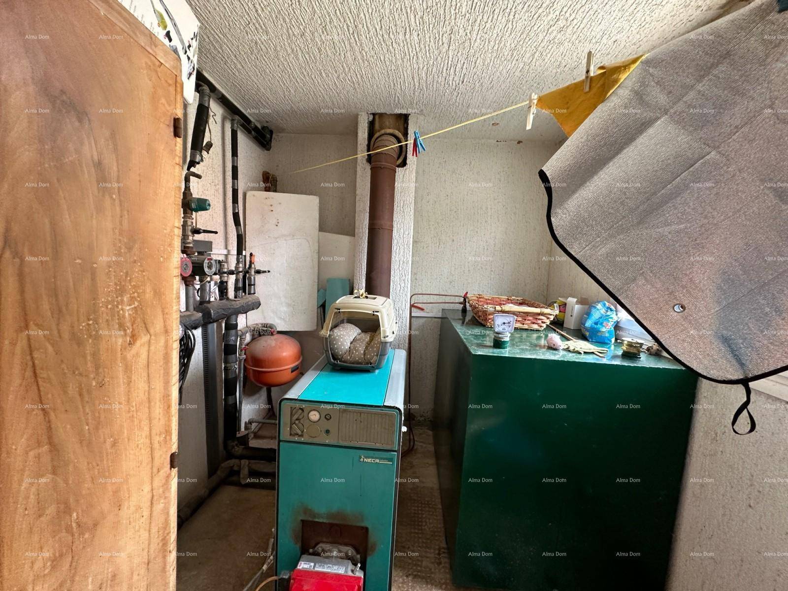 Funktionaler Heizungsraum mit Kessel, Rohrleitungen und einem kleinen Fenster.
