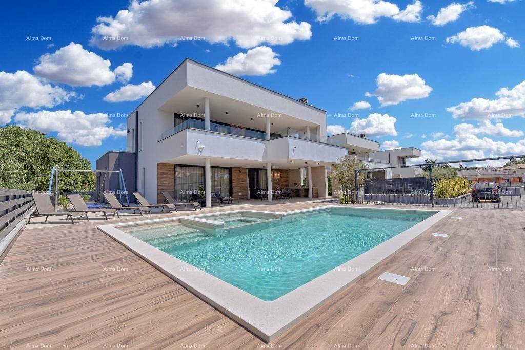 Luxuriöse Villa mit großem Pool und Whirlpool, umgeben von einem Holzdeck unter blauem Himmel.