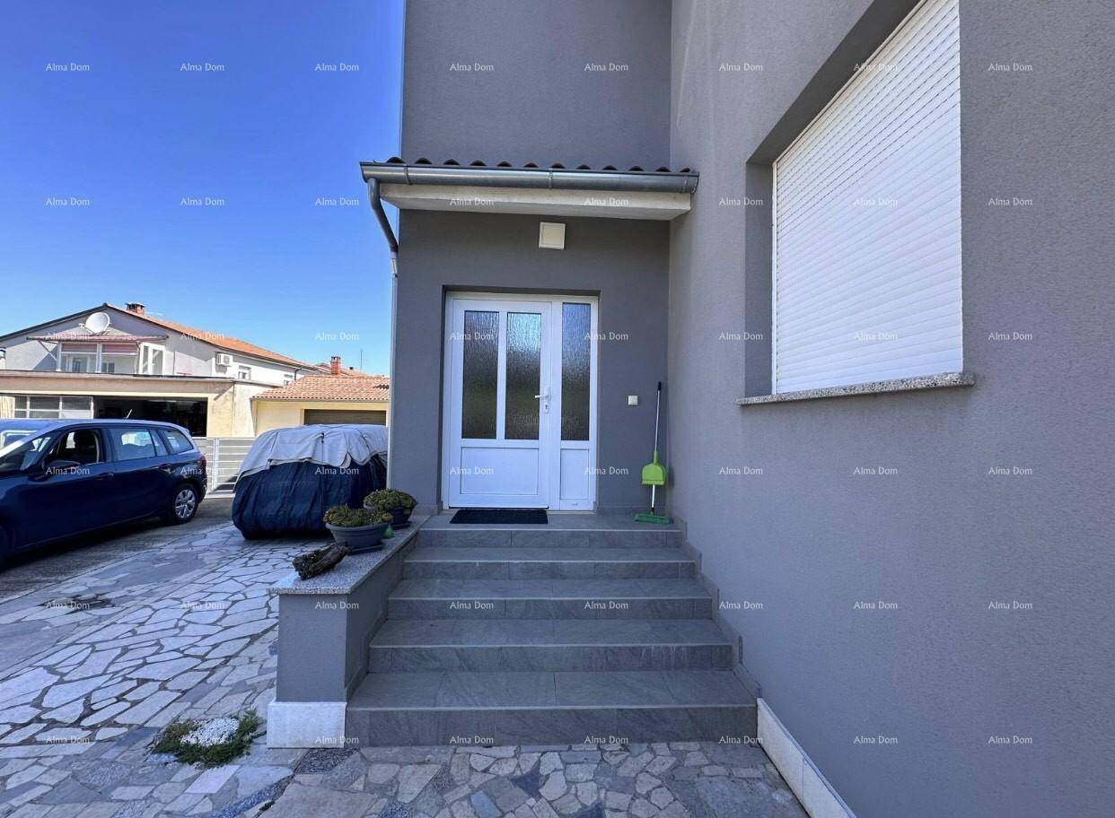 Eingangsbereich des Hauses mit weißen Türen, grauen Stufen und einem Fenster mit Rollladen.