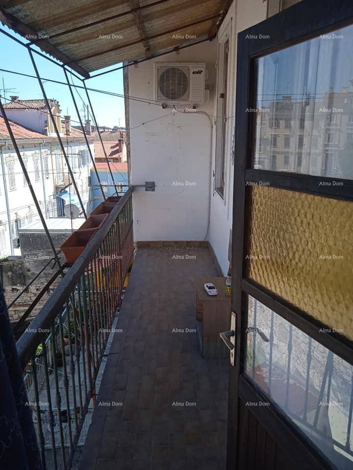 Kleiner Balkon mit Fliesenboden, Metallgeländer und einer Klimaanlage, bietet Blick über die Dächer.