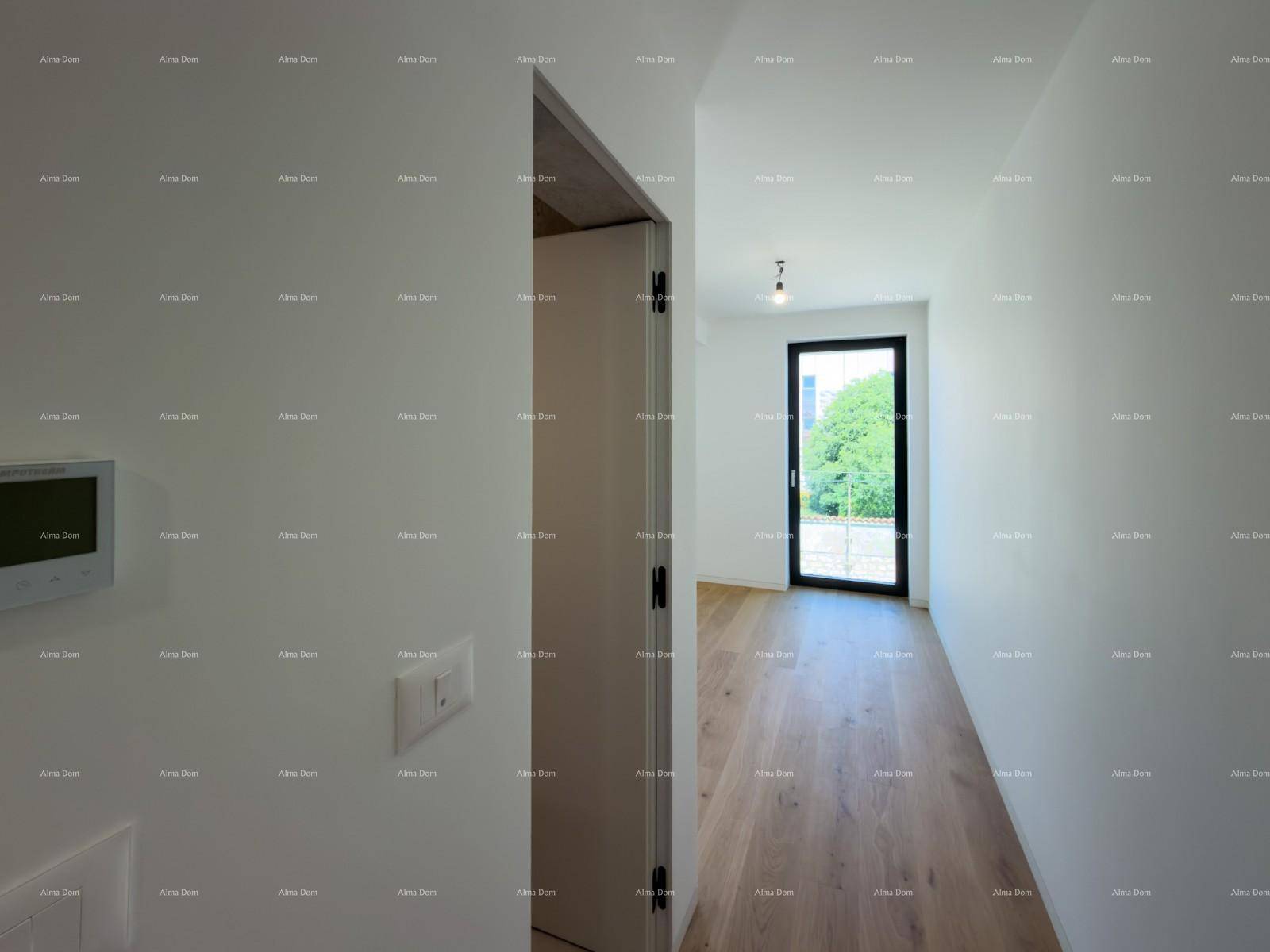 Langer, heller Flur mit Holzboden und weiß gestrichenen Wänden, führt zu einem Fenster mit Grünblick.