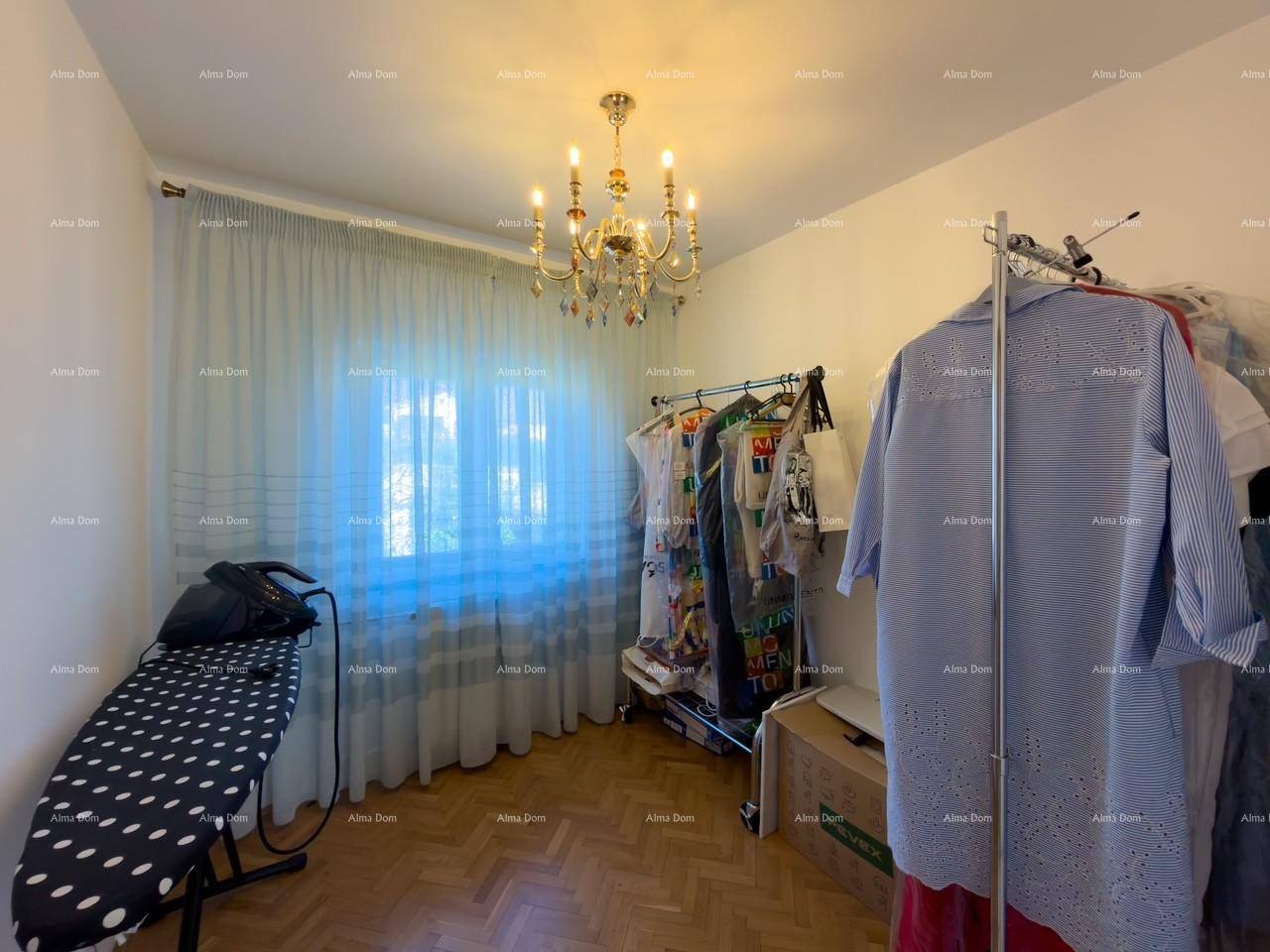 Praktischer Raum mit Bügelbrett und Kleiderständer, beleuchtet durch ein Fenster.