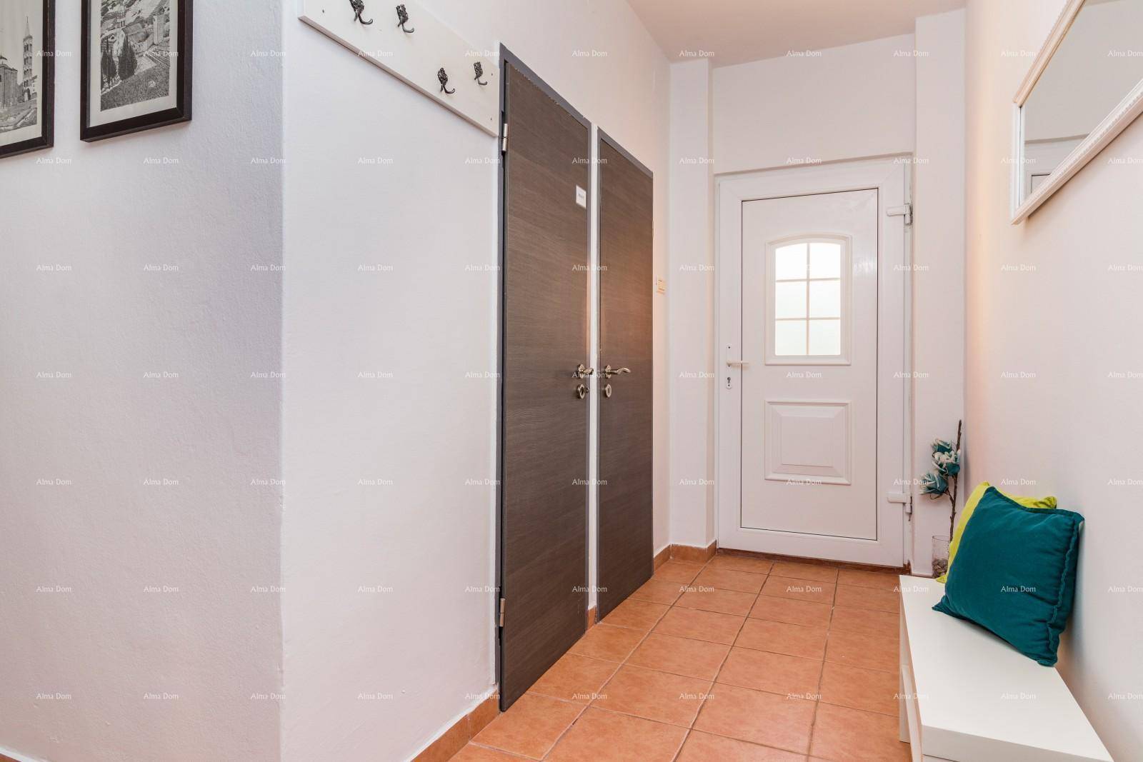 Eingangsbereich mit Fliesenboden, Garderobe und weißer Eingangstür.
