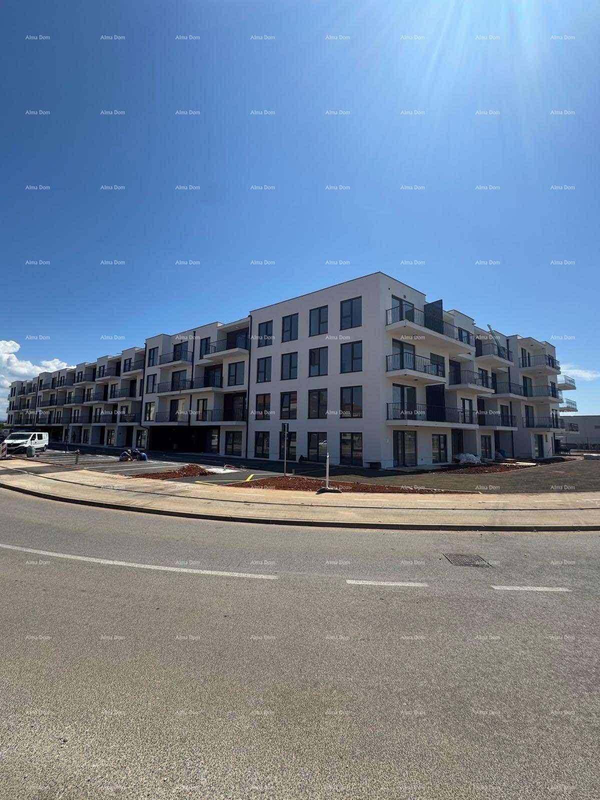 Weitläufige Ansicht eines modernen Apartmentkomplexes mit Balkonen unter blauem Himmel.