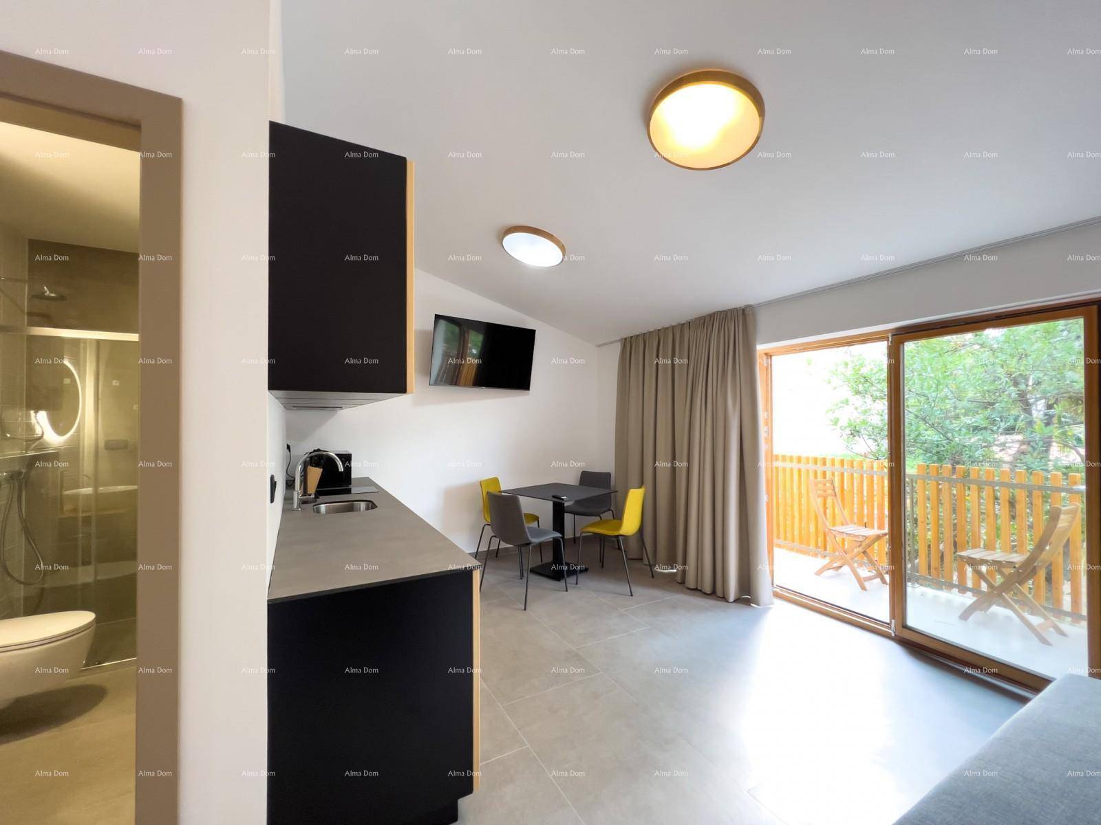 Offener Küchen- und Essbereich mit schwarzer Küchenzeile und direktem Zugang zum Balkon.