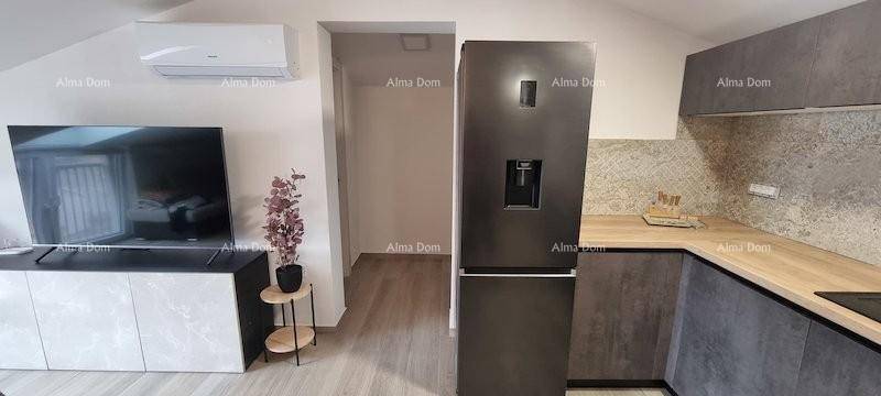 Moderne Küche mit dunklem Kühlschrank, Holz-Arbeitsplatte und Klimaanlage.