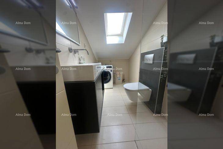 Modernes Badezimmer mit Dusche, WC, Waschmaschine und Dachfenster.
