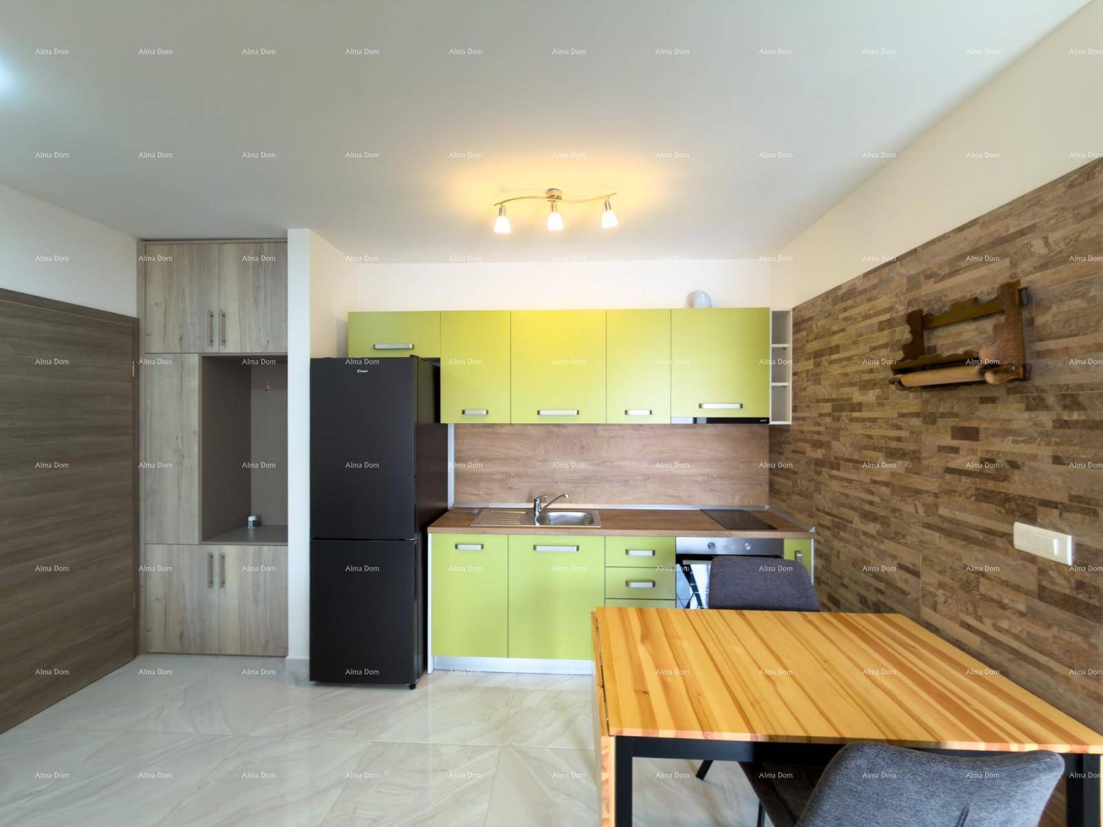 Helle Einbauküche in Grün mit integriertem Kühlschrank und Essbereich.