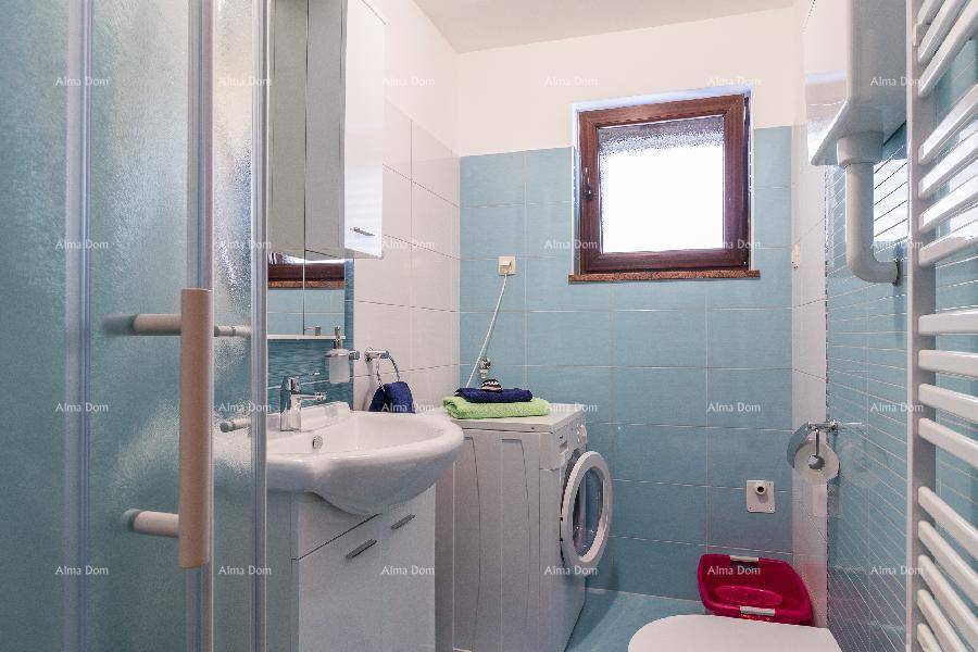 Modernes Badezimmer mit Dusche, Waschmaschine, Fenster und hellblauen Fliesen.