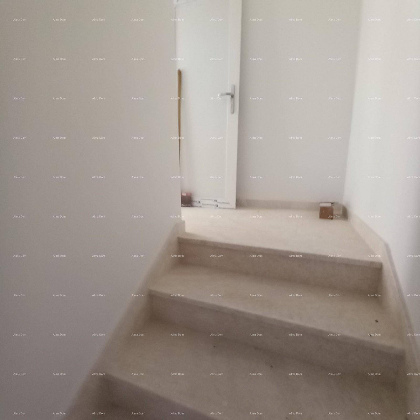 Treppenhaus mit hellen Stufen und weiß gestrichenen Wänden im Neubau.