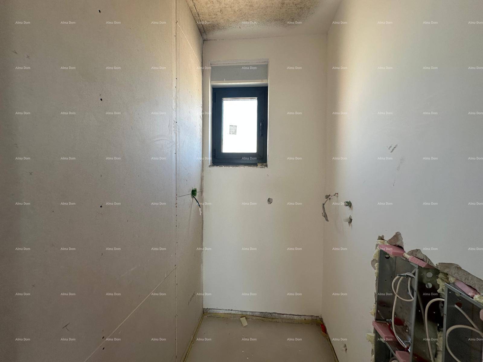 Badezimmer im Rohbau mit Fenster, vorbereiteten Installationen und teilweise gestrichenen Wänden.
