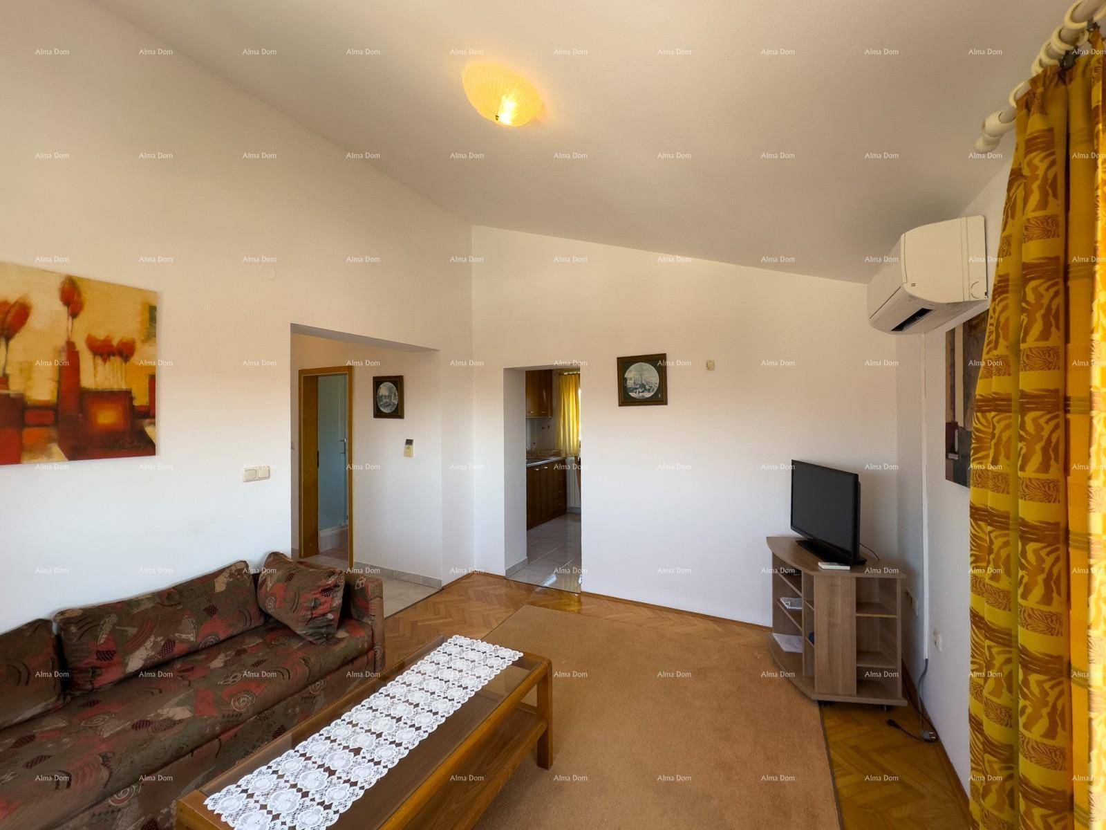 Gemütliches Wohnzimmer mit Sofa, Couchtisch und Fernseher, mit Parkettboden.