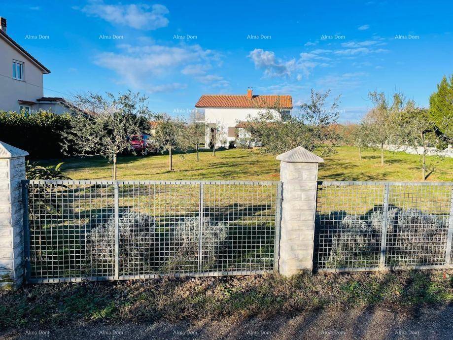 Ansicht des Hauses hinter einem Zaun mit weitläufigem Grundstück.