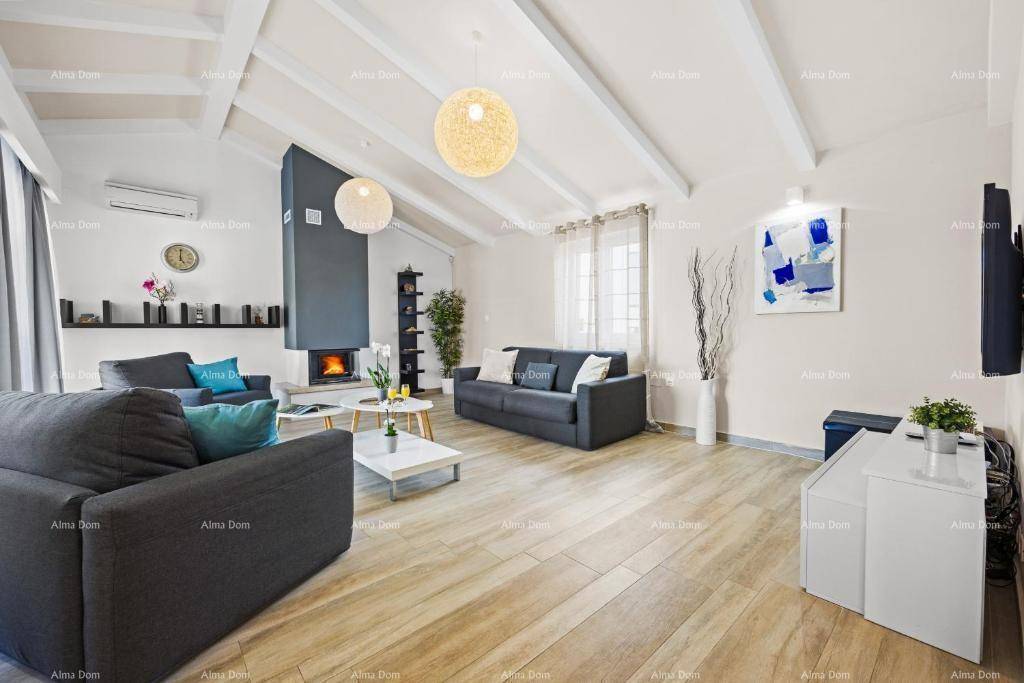 Geräumiges Wohnzimmer mit hohen Decken, Kamin und hellem Holzboden, modern eingerichtet.