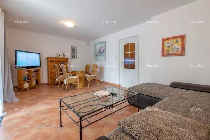 Kombinierter Wohn- und Essbereich mit Sofa, Fernseher und Esstisch auf Terrakottafliesen.